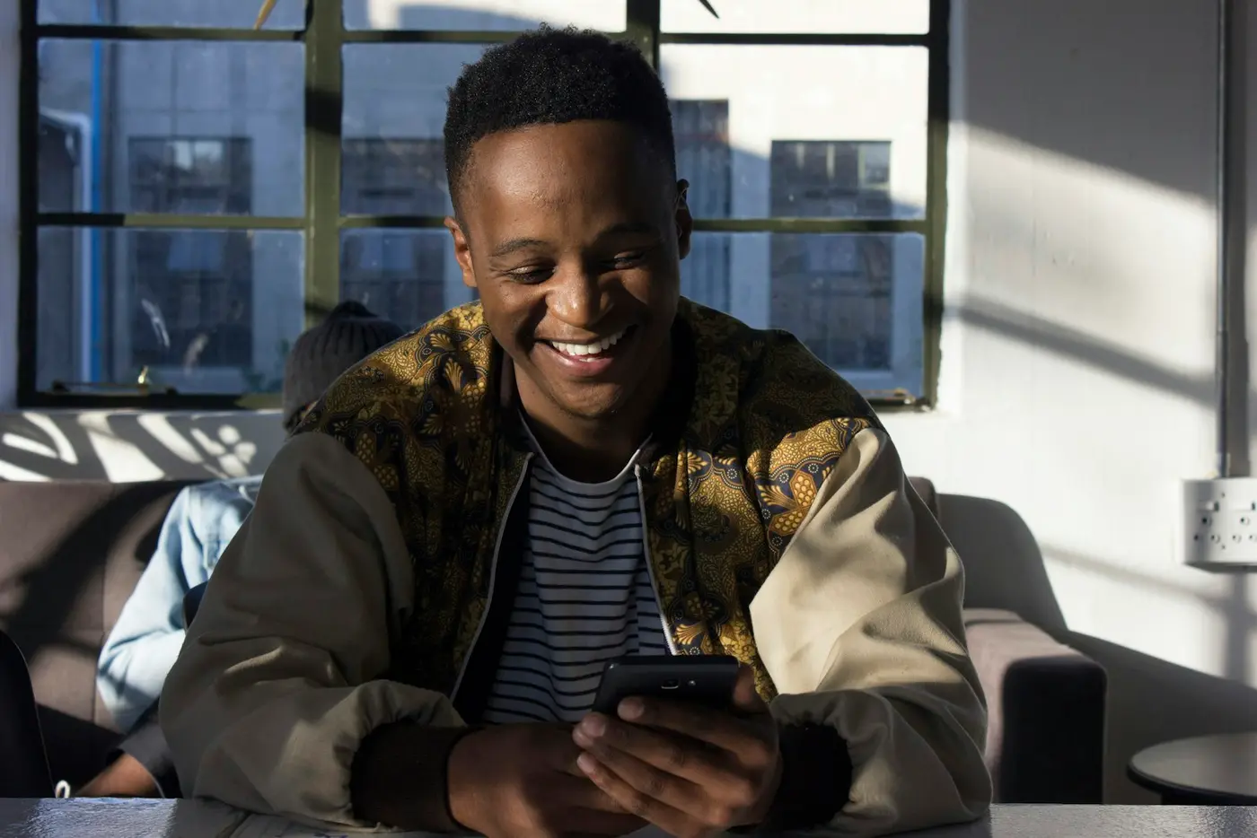 A man smiling at his phone